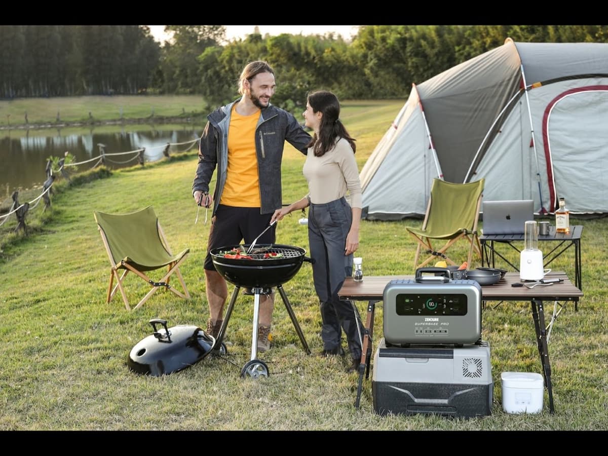 A portable power station running appliances at a campsite with a tent behind